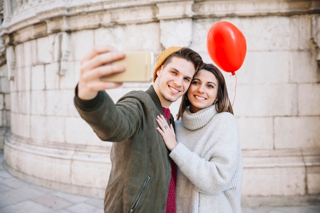 Free Photo couple with balloon taking selfie