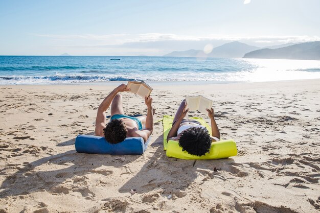 Couple with books at the beach