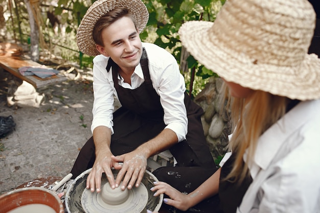 Free photo couple with brown aprons making a vase