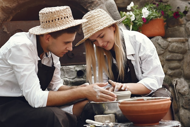 Free Photo couple with brown aprons making a vase