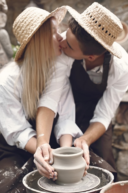 Free Photo couple with brown aprons making a vase