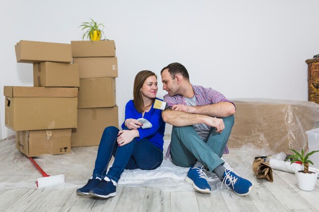 Couple with brushes sitting on floor