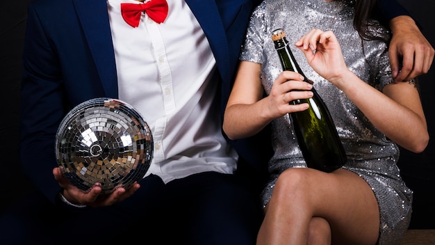 Couple with disco ball and bottle of champagne