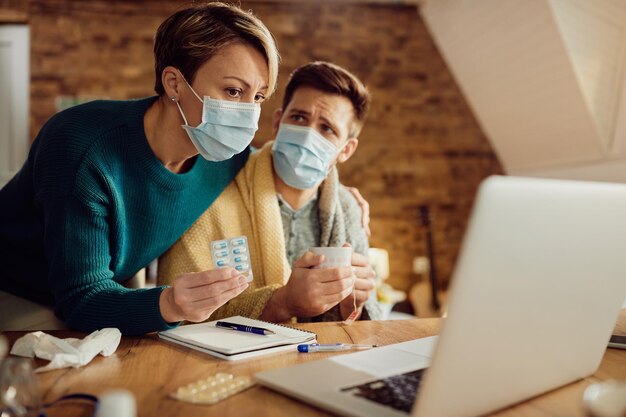 Couple with face masks consulting with doctor via video call about taking medicines