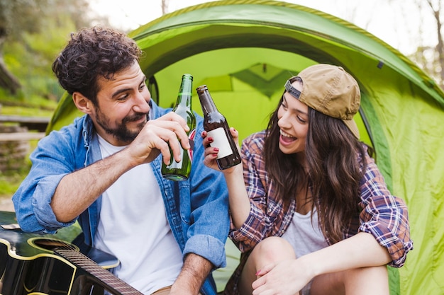 Free Photo couple with guitar clinking bottles