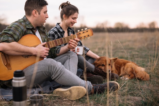 Free photo couple with guitar and pet