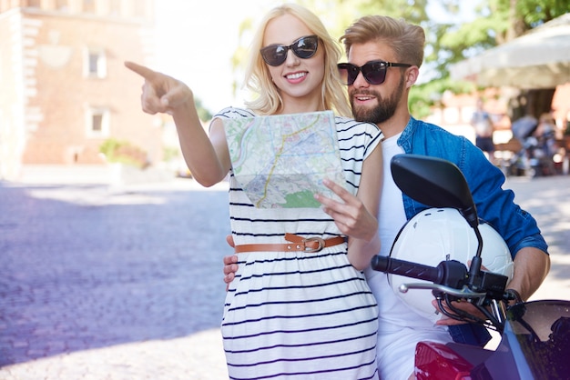 Couple with map and scooter at the city