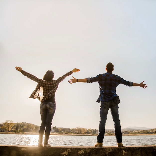 Free photo couple with open arms enjoying nature