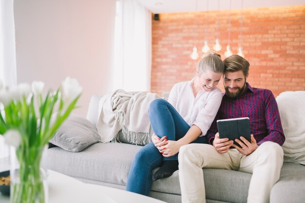 Couple with tablet on sofa