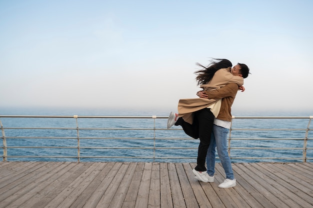 Free Photo couples embracing near the sea