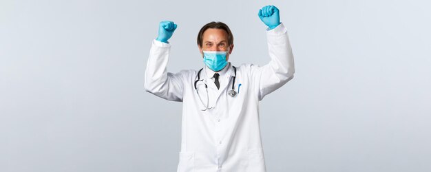 Free photo covid preventing virus healthcare workers and vaccination concept happy excited doctor in medical ma...