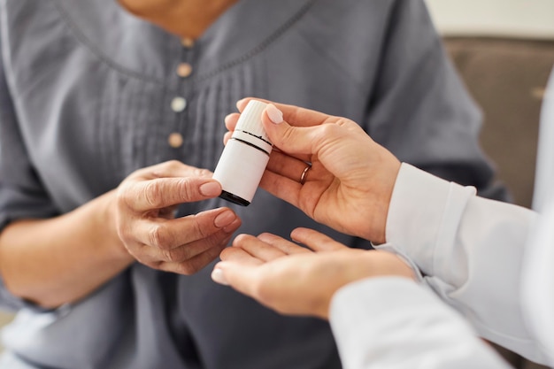 Covid recovery center female doctor giving elder patient pills bottle