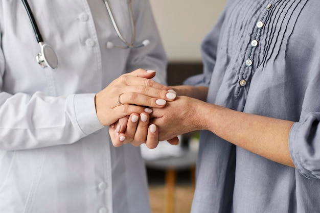 Covid recovery center female doctor holding elder patient's hands