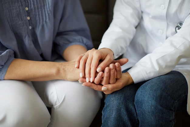 Free Photo covid recovery center female doctor holding elder patient's hands