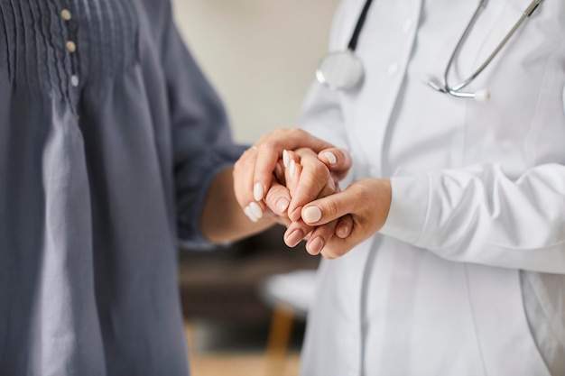 Covid recovery center female doctor holding elderly patient's hands