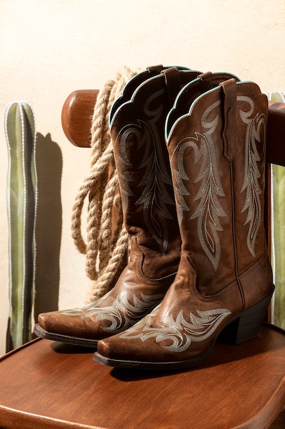 Free photo cowboy inspiration with boots on chair