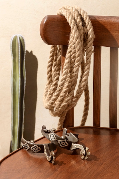 Free Photo cowboy inspiration with rope on wooden chair