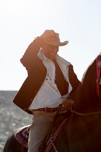 Free Photo cowboy silhouette with horse against warm light