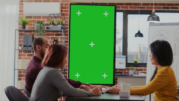 Free Photo coworkers meeting in office with green screen on monitor vertically to plan business strategy. diverse team of people looking at mockup copy space with isolated template and chroma key.