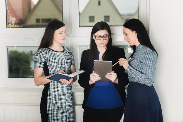 Coworkers with tablet in hall