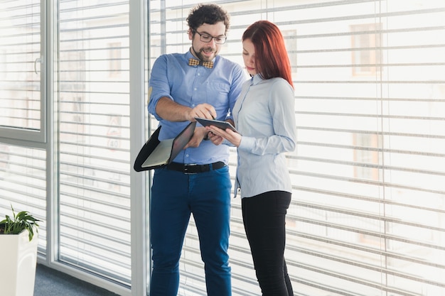 Coworkers with tablet in hall