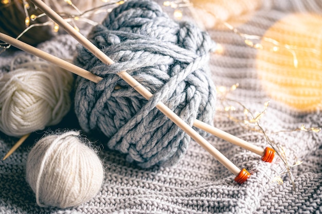 Free photo cozy background with a ball of thread and knitting needles