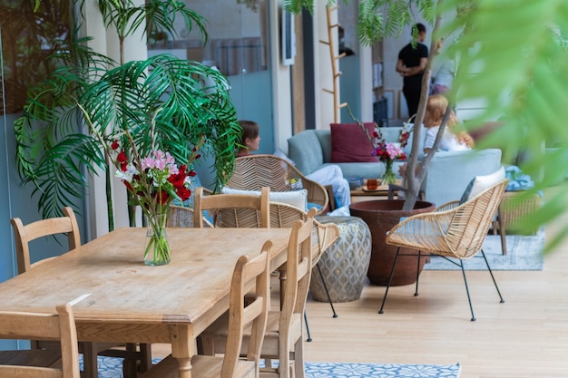 Cozy cafe in the hotel decorated with green plants and flowers