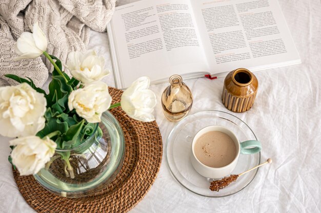 Cozy composition with a bouquet of tulips and a cup of coffee