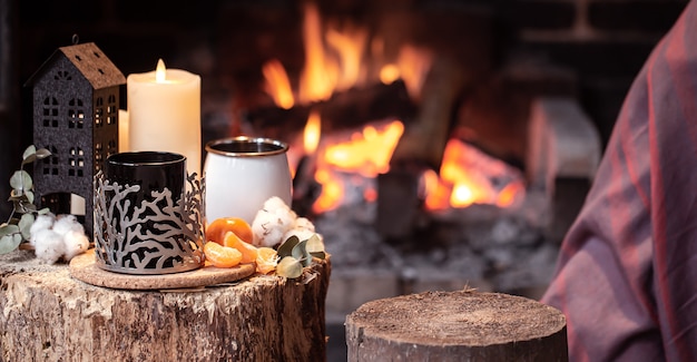 Free Photo cozy composition with a cup, candle and tangerines of a burning fireplace copy space.