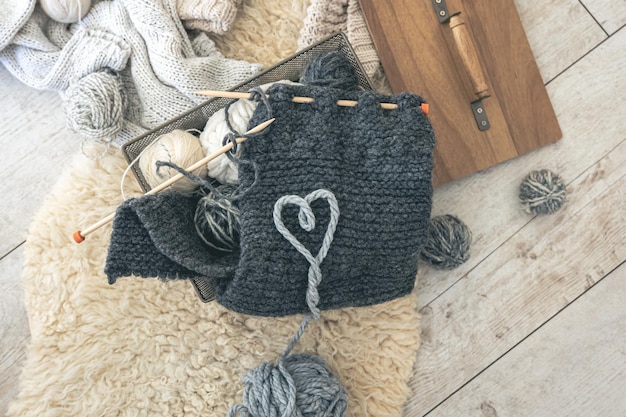 Free photo cozy composition with a knitted element yarn and a heart made of threads