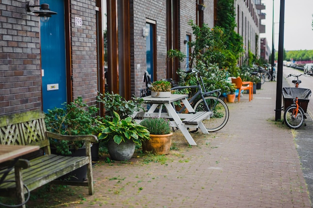 Free photo cozy courtyards of amsterdam, benches, bicycles, flowers in tubs.