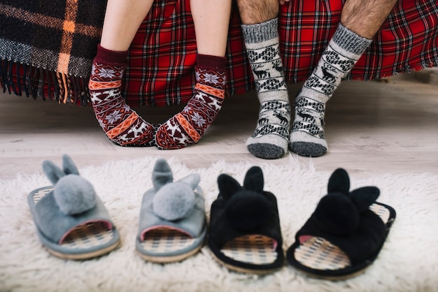 Cozy house shoes on floor near human legs