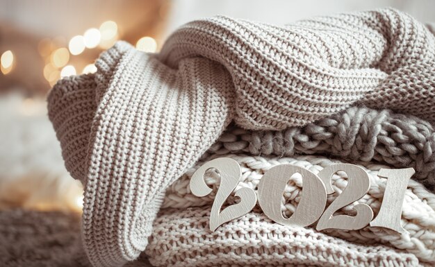 Cozy new year composition with knitted pastel colored wooden numbers 2021 close up.