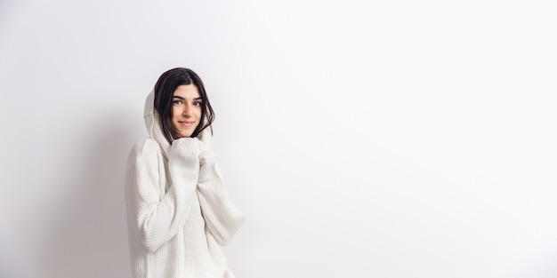 Free Photo cozy. portrait of beautiful brunette woman in comfortable soft long sleeve isolated on white  wall. home comfort, emotions, facial expression, winter mood concept. copyspace.