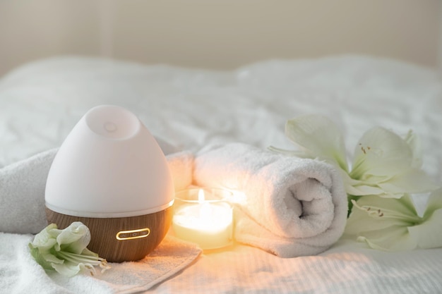 Free Photo cozy spa composition with aroma diffuser candle and flowers