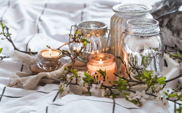 Cozy still life with different candles in bed