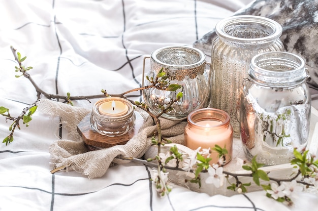 Cozy still life with different candles in bed