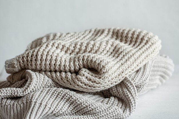 Cozy and warm knitted sweaters in pastel colors close-up.