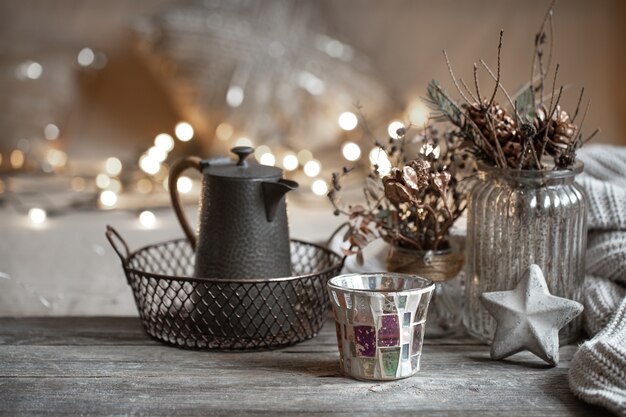 Cozy winter background with details of home decor on a blurred background with lights copy space.