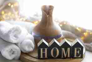 Free photo cozy winter composition with essential oil aroma diffuser and wooden word home