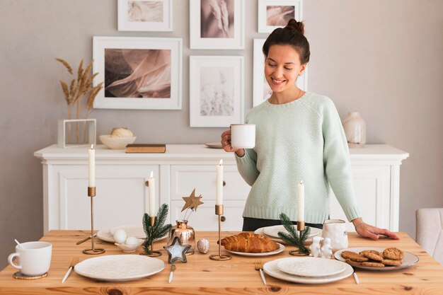 Cozy woman setting table in kitchen