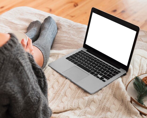 Cozy woman using laptop in bed