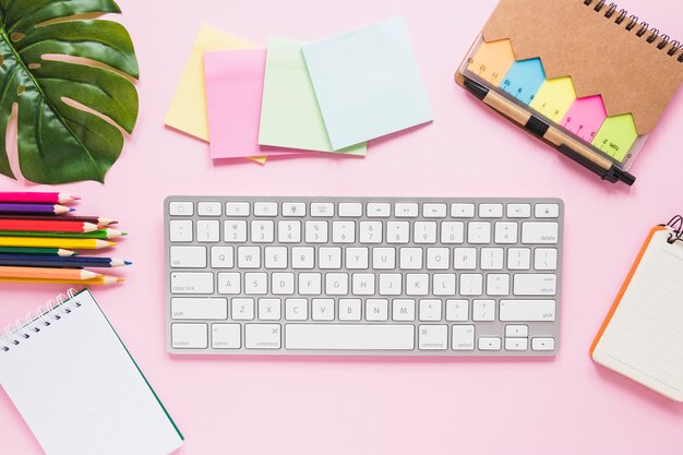 Free photo cozy workplace with keyboard notes and pens