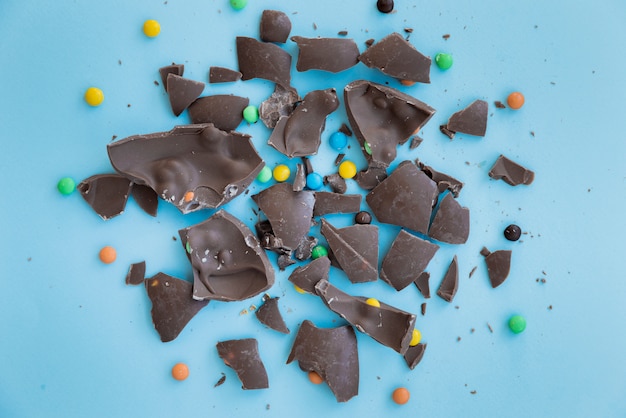 Free photo cracked chocolate with candies on table