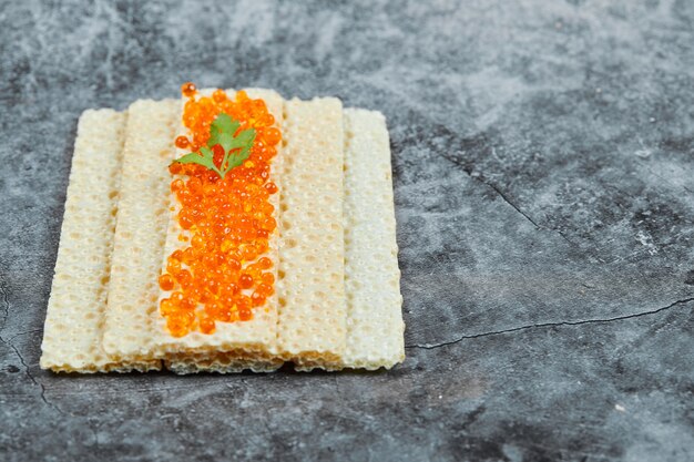 Cracker with red caviar.