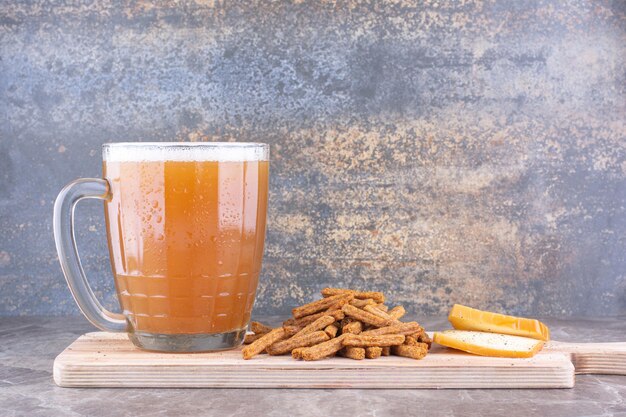 Crackers, cheese and glass of beer on wooden board. High quality photo