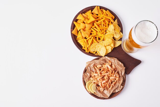 Crackers and chips with a glass of beer.