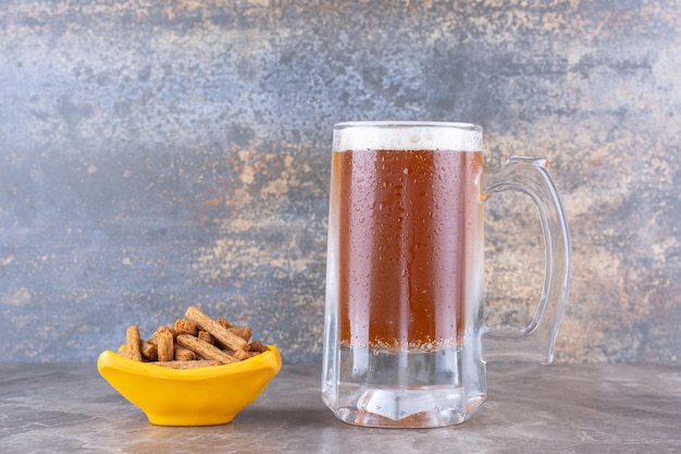 Crackers and glass of cold beer on marble table. High quality photo