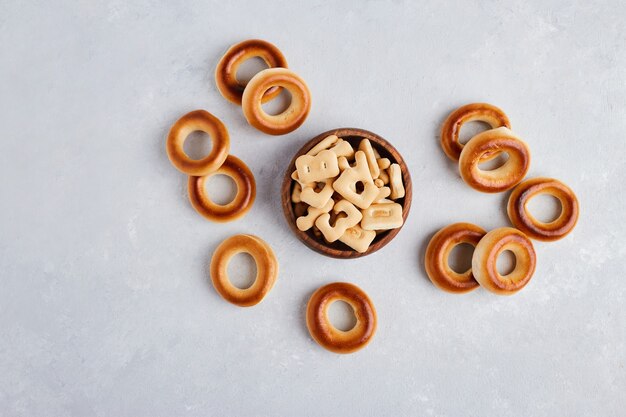 Crackers and pastry buns on white surface, top view. 