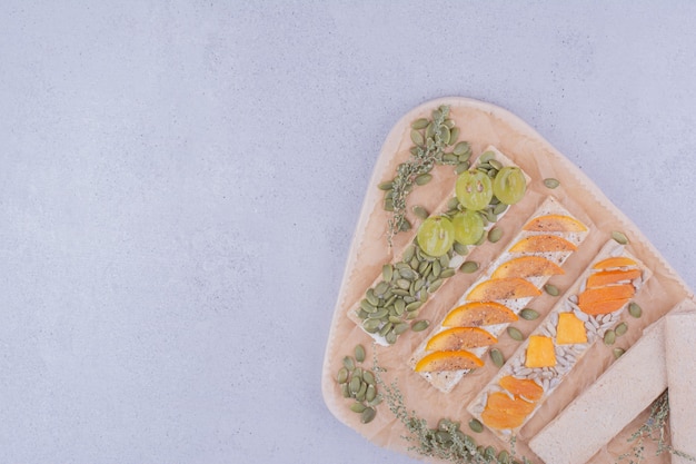 Crackers with sliced fruits and pumpkin seeds